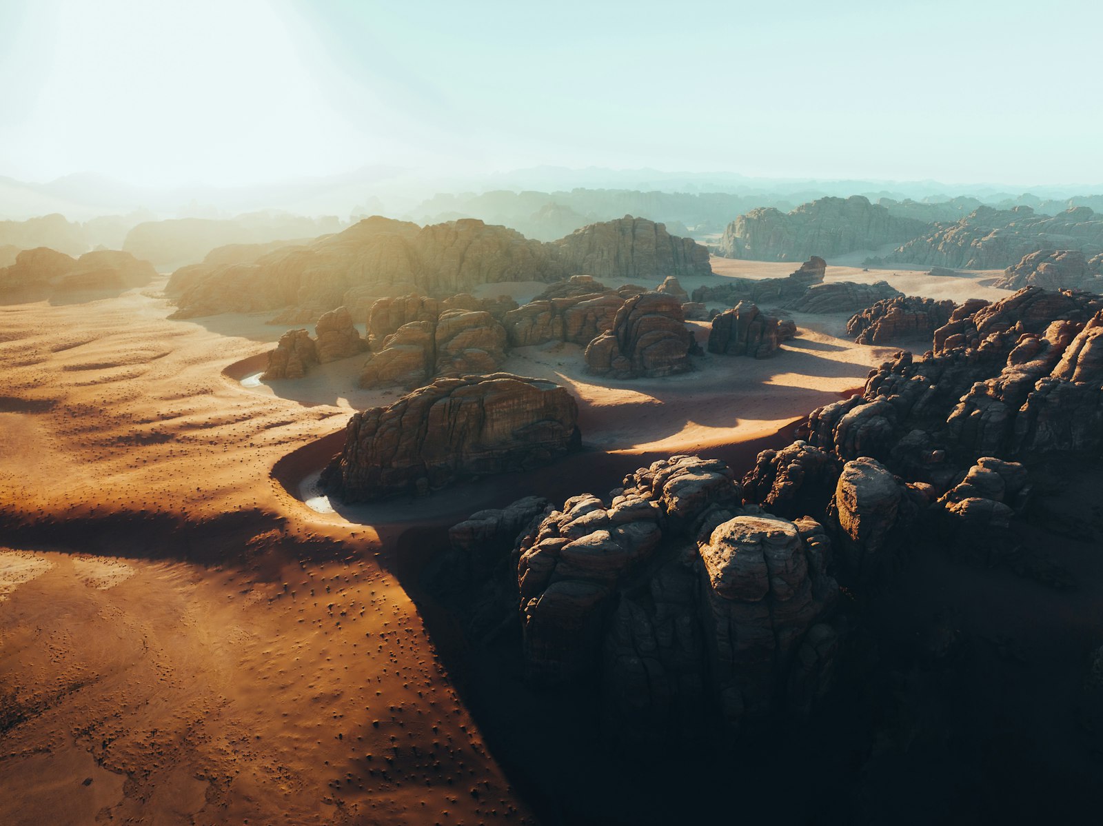 Vista aérea de dunas y formaciones rocosas del desierto al atardecer
